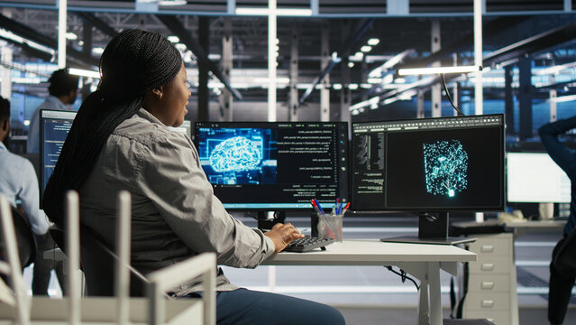 Server facility computing specialist applying AI ML models to set up hardware. IT specialist working with AI programming languages on workstation in server environment, optimizing system.