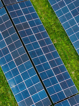 Aerial view of solar panels arranged in rows across a green field in Suntazi, Ogre Municipality, Latvia.