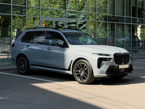 Nardo gray BMW X7 G07 in the street parking lot. The modern vehicle exterior SUV car BMW X7 G07. Premium Germany SUV Car BMW X7 G07 summer day in the street parking.