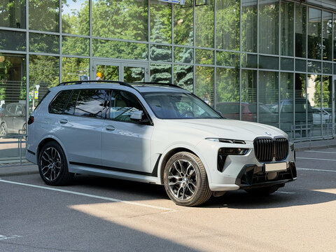 Nardo gray BMW X7 G07 in the street parking lot. The modern vehicle exterior SUV car BMW X7 G07. Premium Germany SUV Car BMW X7 G07 summer day in the street parking.