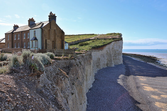 Cliffside cottages at Birling Gap near Seven Sisters white chalk cliffs, South Downs National Park; English Channel coastal landscape with rugged cliff edge and traditional buildings, East Sussex, UK