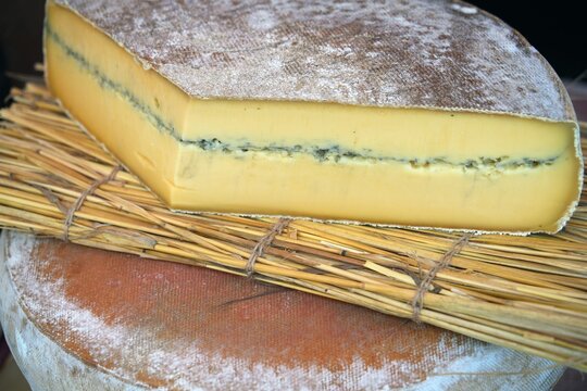 Wheel of fresh morbier cheese at a farmers market in France
