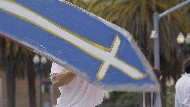Slow Motion Shot Of Man Spinning Blue Cross Board In San Francisco Plaza