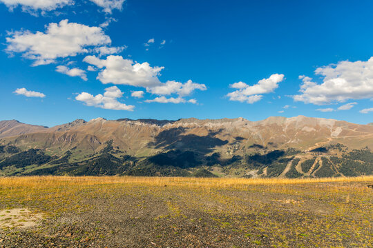 Horizontal sunny alpine mountain landscape with blue sky and clouds in Arkhyz Karachay Cherkessia Russia.