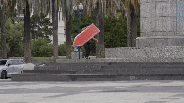 Man Swinging Blue Cross Board on Granite Plaza Steps In San Francisco Wide Shot
