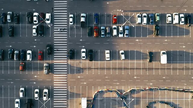 Cars driving on parking lot and walking pedestrians and go-kart track, high view from above