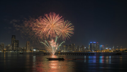 Fototapeta premium 港町の夜空に大きな花火が開く祝祭の水辺風景