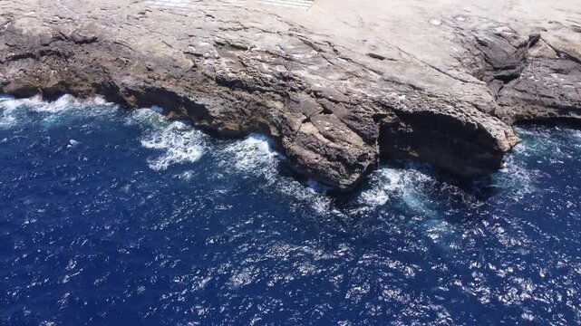 Aerial view of cliffs, Zebbug, Gozo, Malta. Waves crashing on the rugged limestone. High quality 4k footage