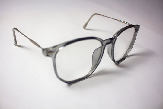 Modern transparent grey frame eyeglasses with thin metal temples isolated on a clean white background