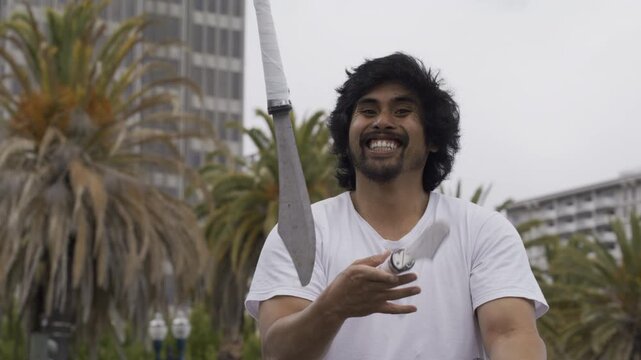Man Juggling Knives While Smiling In San Francisco Plaza During Day - Medium Shot