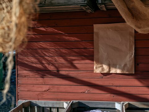 Blank kraft paper poster mockup on a weathered russet wood plank wall at an autumn farmers market for seasonal event announcements