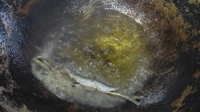 Closeup of Marinated Fish Frying in Hot Oil Inside a Wok