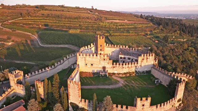 Aerial view of medieval castle Soave surrounded by rolling hills and vineyards in Verona province Italy.