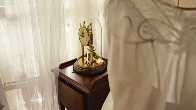 Antique pendulum clock under glass dome showing passing time and motion.