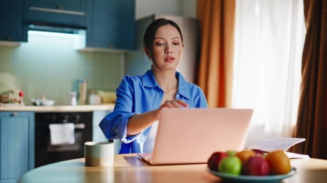 Young Asian freelancer drinking coffee kitchen window, finishing remote work pause
