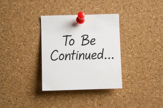 White sticky note with 'To Be Continued...' text pinned to a cork board