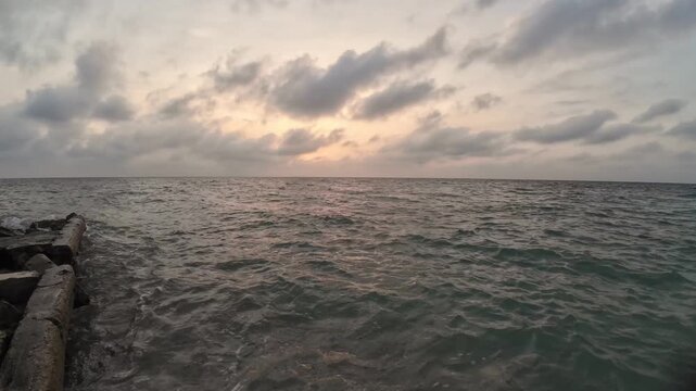 Cloudy tropical sunset over a wavy sea in colombia