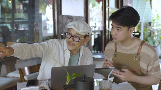 Modern small business digital management concept with entrepreneur reviewing data on laptop while coordinating with worker, using technology for workflow planning, improving efficiency performance