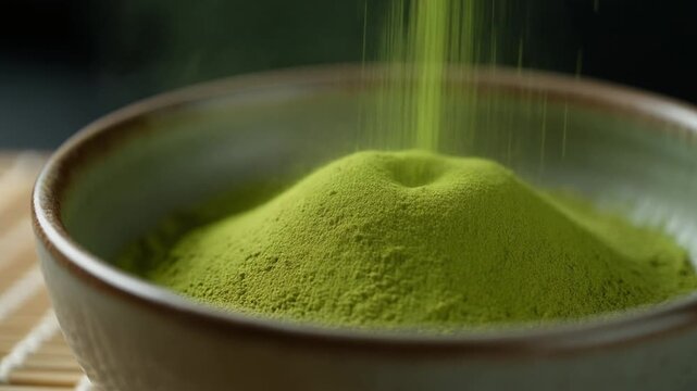 Pouring vibrant green matcha powder into ceramic bowl, close-up food preparation, natural lighting, top view, organic tea concept