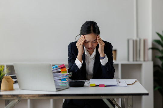 Stressed business woman suffering from headache in office