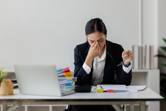 Businesswoman experiencing stress and headache due to overwork