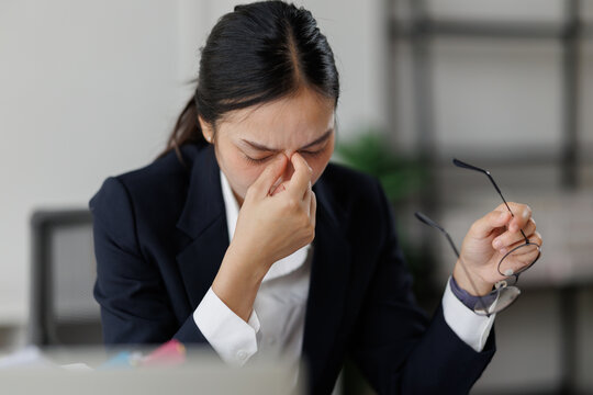 Young asian businesswoman feeling tired having headache at office