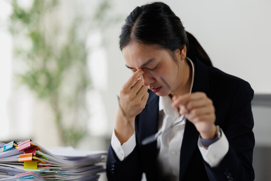 Stressed business woman feeling headache and eye strain working