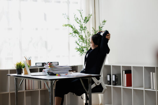 Businesswoman stretching at office desk taking a break