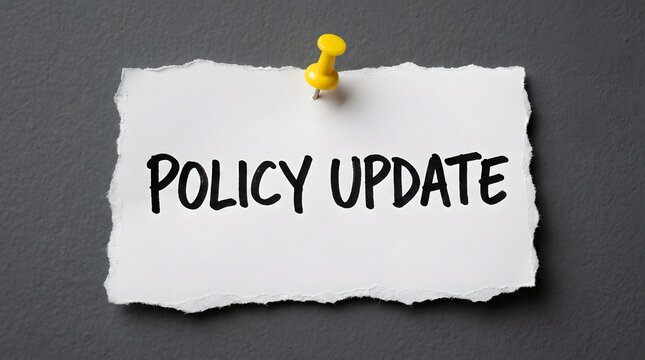Torn paper note with policy update text pinned on gray background
