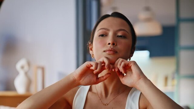 Facial massage woman doing face yoga home. Close up portrait skincare routine.