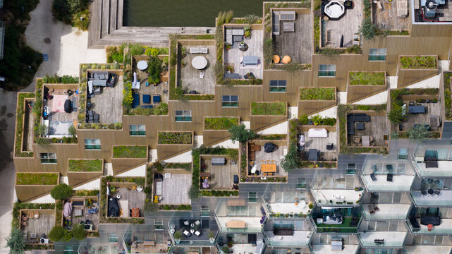 Aerial view of the Sluishuis building featuring terraced wooden balconies, lush green roofs, and modern architectural design in Amsterdam, North Holland, Netherlands.