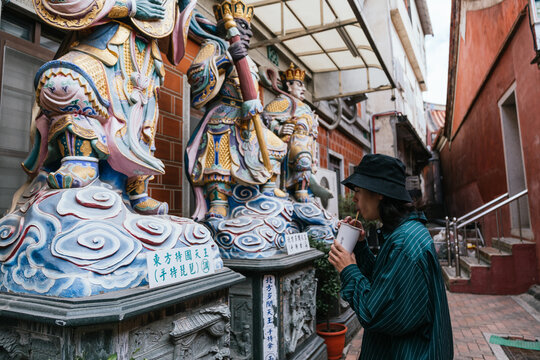 Person exploring traditional taiwanese temple with buddhist statues