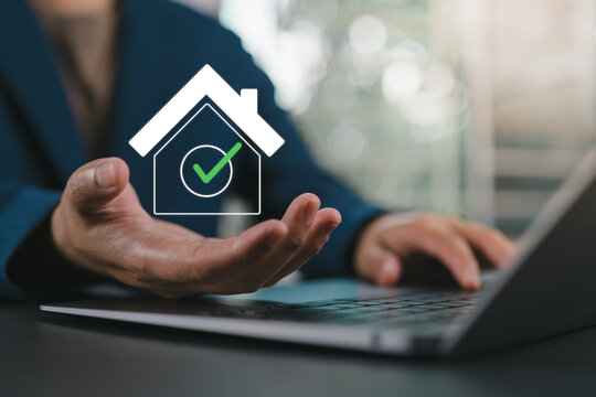 Real estate protection, A person holds a digital house icon with a checkmark, symbolizing approved real estate or property verification in a digital context.