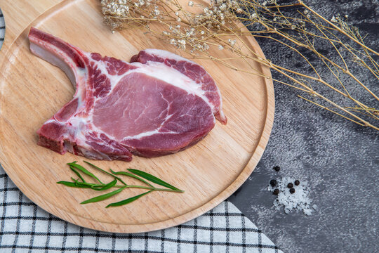 Fresh beef is placed on a brown wooden tray.