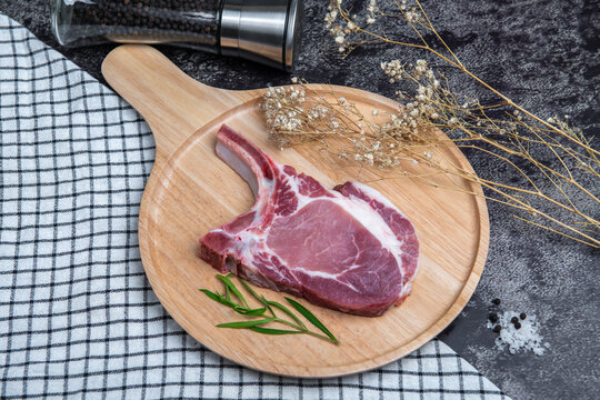 Fresh beef is placed on a brown wooden tray.