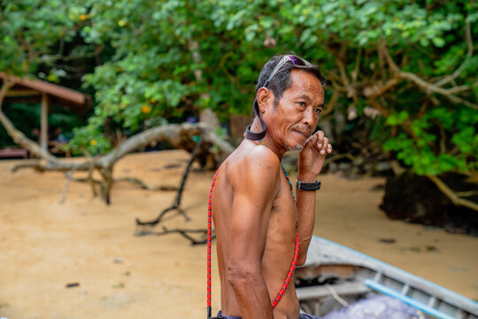 Moken man on sandy beach looking away