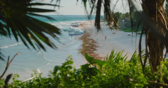 Tropical beach coastline with boats framed by palm trees Playa Santa Fe Tulum Mexico