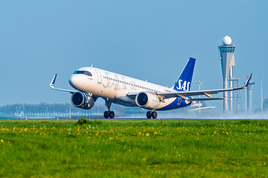 Amsterdam, Netherlands, 21.04.2023 - A SAS Scandinavian Airlines passenger jet aircraft taking off from the runway at Schiphol Airport with the control tower in the background.