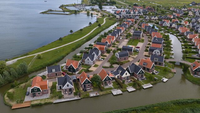 Aerial view of EuroParcs Resort Port of Amsterdam with waterfront holiday homes, canals, and wooden decks in Uitdam, Noord-Holland, Netherlands.