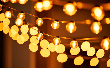 Fototapeta premium String of warm yellow christmas lights, glowing bulbs on copper wire string lights yellow lights warm lighting