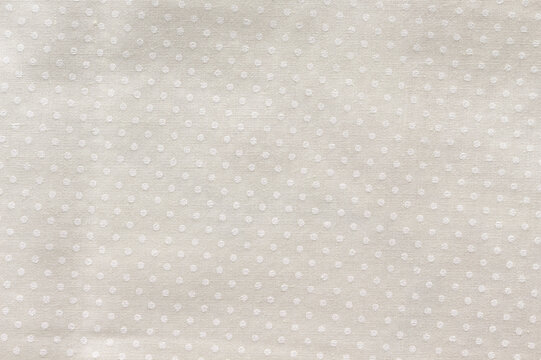 Cream cotton fabric with a small polka dot pattern