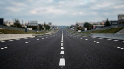 Obraz premium Straight Asphalt Road Stretching Towards the Horizon on an Overcast Day.