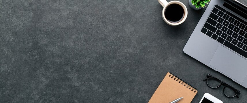 Desk with laptop and coffee on a professional office workspace flat lay top view