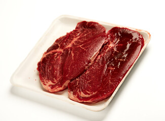 Obraz premium Raw beef steaks in food tray for butcher shop concept isolated on white background 