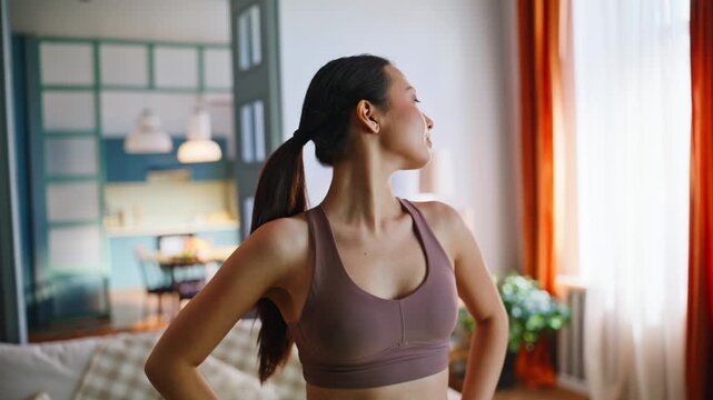 Asian woman stretching neck shoulders home workout. Fitness girl exercise.