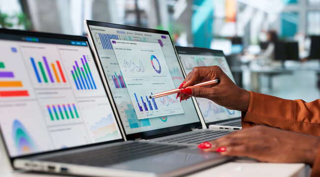 Young Financial Analyst Reviews Market Trends On Laptop