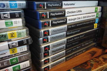 Fototapeta premium North Haven, South Australia - July 5 2026: Stack of PlayStation 2 video game cases on a shelf
