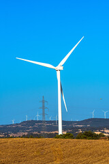 Fototapeta premium Large wind turbine with power lines in rural landscape
