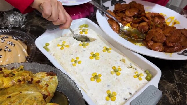 traditional Iranian cuisine of Bowl of Olivier salad on dining table and creamy potato peas with mayonnaise egg and meat beef garnished ceramic Persian gathering family Iran serving white food recipe