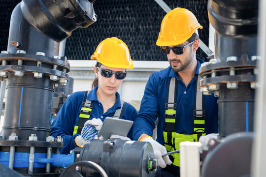 Industrial technicians with tablet for pipeline inspection at manufacturing plant, Engineer checking pipe system maintenance with digital device, Quality control team monitoring industrial water pipes
